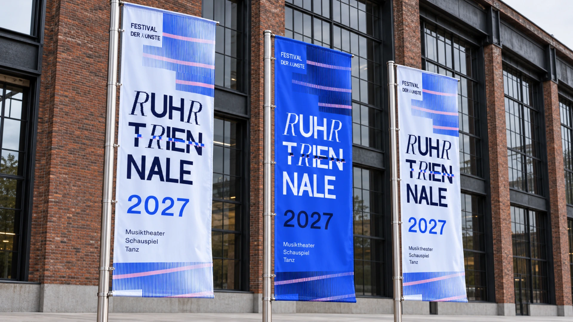 Drei rechteckige Festivalfahnen in Eisblau und Kobalt vor einer industriellen Backsteinfassade.
